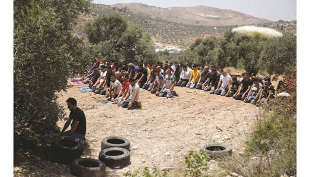 Palestinians perform prayers during a protest against settlements, in the occupied West Bank, yesterday.