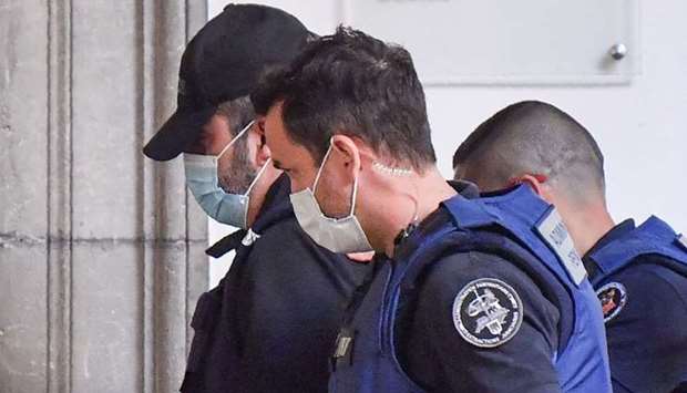 Nordahl Lelandais (L) arrives escorted by French prison administration (administration penitentiaire) officers at the courthouse of the French Alps city of Chambery on the first day of his trial for the murder of French army Corporal Arthur Noyer in 2017.