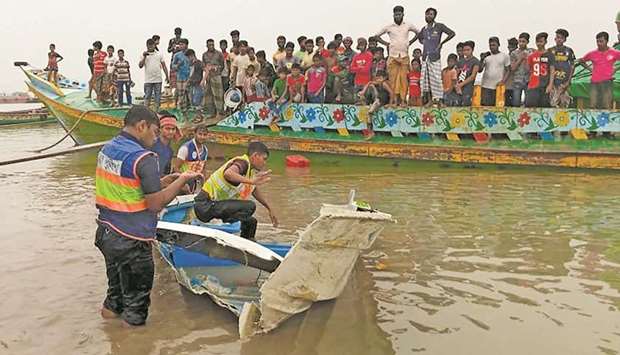 Policemen inspect the speedboat that was carrying passengers when it collided with a vessel transporting sand killing 26 people, in Madaripur, Bangladesh, yesterday.