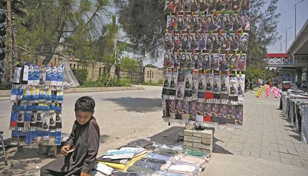 A boy selling face masks waits for customers at a stall along a street in Rawalpindi.