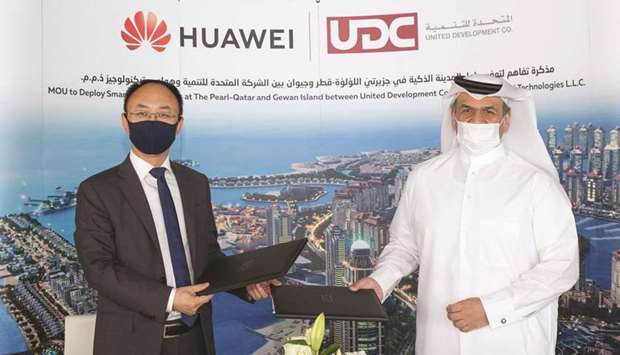 UDC president and CEO and member of the board Ibrahim Jassim al-Othman and Huawei Qatar CEO Fan Tao exchange MoUs after the signing ceremony.