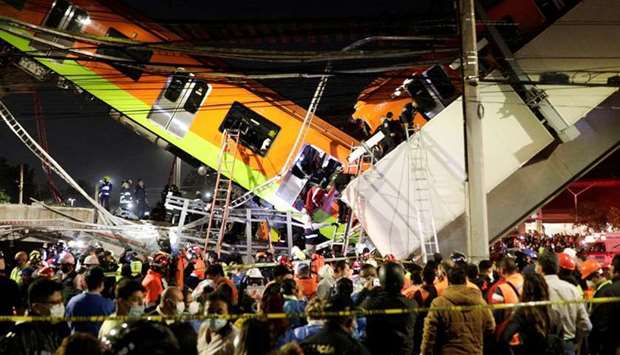 Rescuers work at a site where an overpass for a metro partially collapsed with train cars on it at Olivos station in Mexico City, Mexico