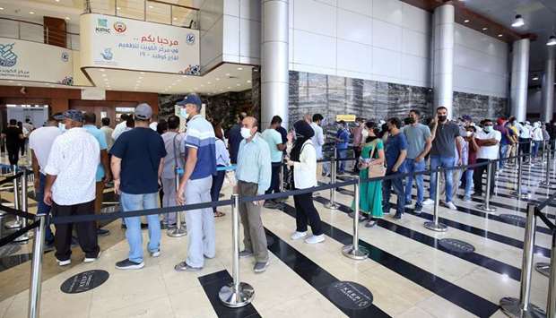 People queue up to receive a dose of the Covid-19 coronavirus vaccine at a vaccination centre in Kuwait City
