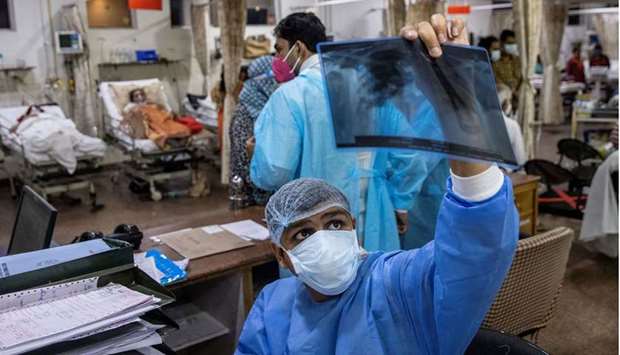 A doctor treating patients suffering from the coronavirus disease (Covid-19), looks at a patient's x-ray scan during his shift at Holy Family Hospital in New Delhi