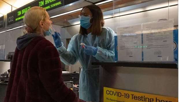 A traveller receives a nasal swab from a nurse at a Covid-19 test site inside Terminal B at Los Angeles International Airport. A travel rebound this summer in many countries may hit the air pocket as PCR tests, the so-called gold standard, will make journey too expensive for many individuals and families.