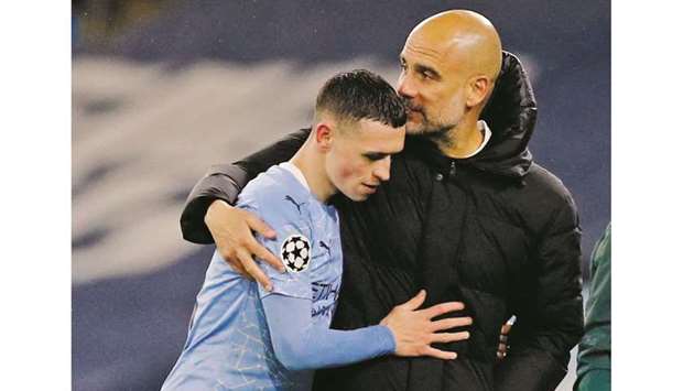 Manchester City manager Pep Guardiola (right) with midfielder Phil Foden after the Champions League semi-final win over Paris St Germain on Tuesday. (Reuters)