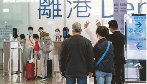 People wave in the departures hall at the Hong Kong International Airport. As Singaporeu2019s government assesses any potential change to a planned travel bubble with Hong Kong following a spike in local virus cases, families on both sides of the South China Sea are waiting and watching with bated breath u2013 again.