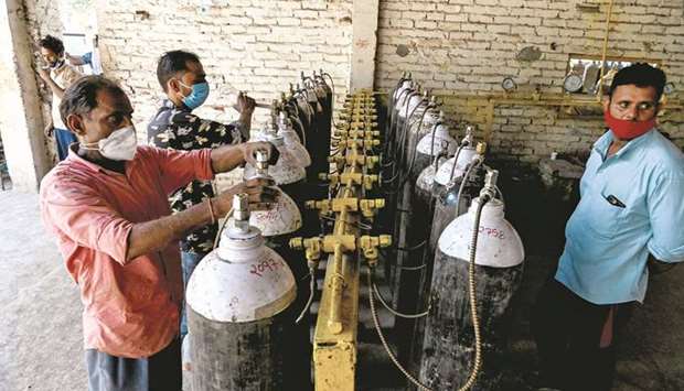 Employees at an oxygen refilling centre in Moradabad, India, refill cylinders for coronavirus patients.