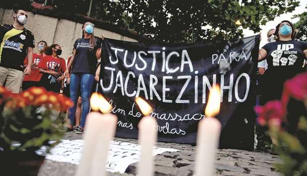 People attend a protest against police violence, outside the Jacarezinho slum, following a police operation that resulted in 25 deaths in Rio de Janeiro. The banner reads u2018Justice for Jacarezinhou2019.