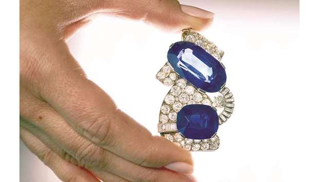 A staff holds a 1930s sapphire and diamond brooch, featuring the largest Kashmir sapphire ever to appear at auction, during a preview at Sothebyu2019s before their auction in Geneva.