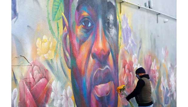 (File photo) A man places flowers at a mural of George Floyd after the verdict in the trial of former Minneapolis police officer Derek Chauvin, found guilty of the death of Floyd, in Denver, Colorado, US., recently. (REUTERS)