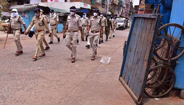 Police personnel patrol along a deserted street during restrictions imposed as a preventive measure against the spread of the Covid-19 coronavirus in the old quarters of Jabalpur