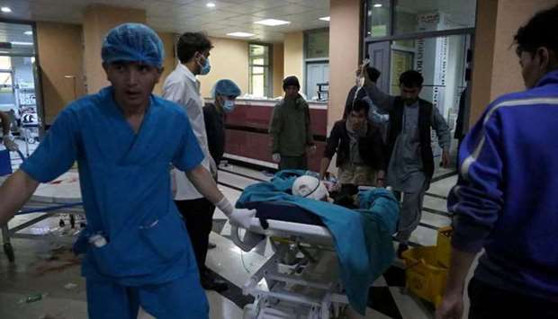 An injured man is being brought on a stretcher to a hospital following a blast outside a school in the west Kabul district of Dasht-e-Barchi, that killed at least 25 people and wounded scores more including students.