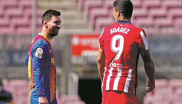 Atletico Madridu2019s Luis Suarez (right) speaks with Barcelonau2019s Lionel Messi before the La Liga match in Barcelona yesterday. (Reuters)