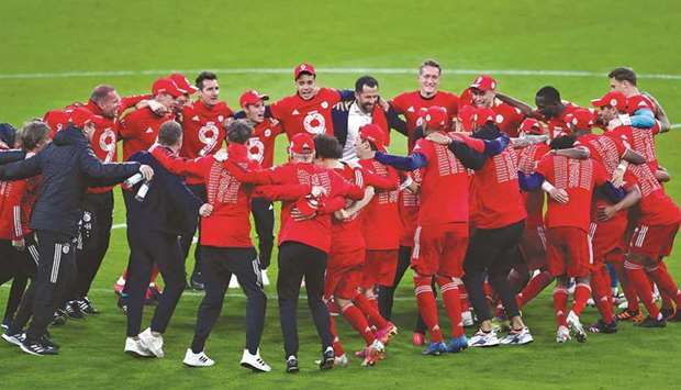 Bayern Munichu2019s Robert Lewandowski (centre) celebrates his hat-trick against Borussia Moenchengladbach yesterday. (AFP)