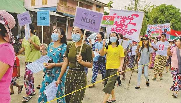 This handout photo from Kachinwaves taken and released yesterday shows protesters marching with placards supporting the opposition National Unity Government (NUG) during a demonstration against the military coup in Hpakant in Kachin state.