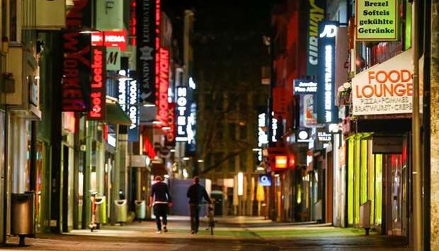 People walk down the empty Hohe Strasse shopping district during a night-time curfew, amid the coronavirus disease pandemic, in Cologne, Germany, yesterday. REUTERS
