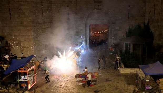 Palestinians react to a stun grenade fired by Israeli police during clashes at Damascus Gate on Laylat al-Qadr during the holy month of Ramadan, in Jerusalem's Old City. REUTERS