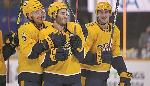 Nashville Predators center Luke Kunin (centre) is congratulated by teammates after scoring two goals in the playoff-clinching win over the Carolina Hurricanes at Bridgestone Arena in Nashville. (USA TODAY Sports)