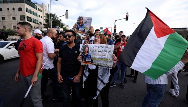 Palestinian protestors shout slogans and hold Palestinian flags and signs with the photo of Al Jazeera reporter Shireen Abu Akleh, who was killed during an Israeli raid in Jenin in the occupied West Bank, near her house in Jerusalem. REUTERS