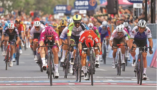 Team Groupama-FDJu2019s French rider Arnaud Demare (left) crosses the finish line to win ahead of Team Lottou2019s Australian rider Caleb Ewan (centre) the 6th stage of the Giro du2019Italia 2022 cycling race, 192 kilometres between Palmi and Scalea, Calabria, yesterday. (AFP)