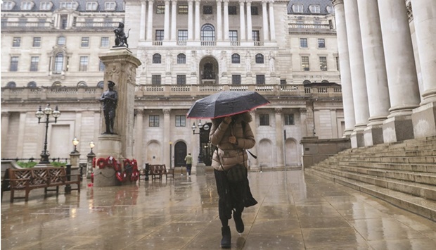 A pedestrian walks past the Bank of England in the City of London. The BoE is being warned it may have to hike interest rates higher than investors expect, even as the risk of recession mounts, in part because it has lost much of its power to control inflation.