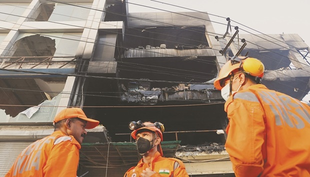 National Disaster Response Force (NDRF) and fire brigade personnel conduct a search and rescue operation after a fire broke out in a commercial building, in New Delhi, India, May 14, 2022. (REUTERS)