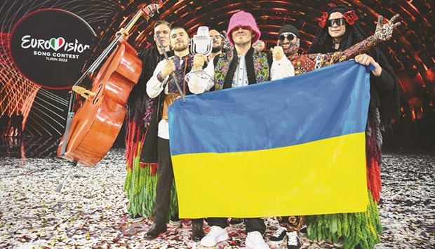 Members of the band u201cKalush Orchestrau201d pose onstage with the winneru2019s trophy and Ukraineu2019s flags after winning on behalf of Ukraine the Eurovision Song contest 2022 at the Pala Alpitour venue in Turin. (AFP)