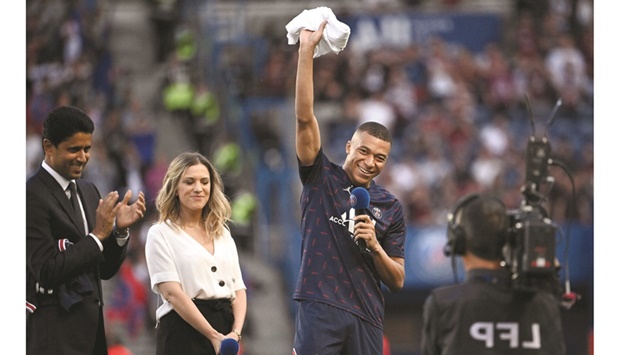 Paris Saint-Germainu2019s French forward Kylian Mbappe (right) addresses the fans after the announcement he staying at PSG until 2025 as the clubu2019s PSG president Nasser al-Khelaifi (left) claps at the Parc des Princes stadium in Paris yesterday. (AFP)