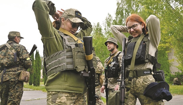 Fighters of the territorial defence unit, a support force to the regular Ukrainian army,  share a light moment after taking part in a training exercise outside Kyiv yesterday. (AFP)