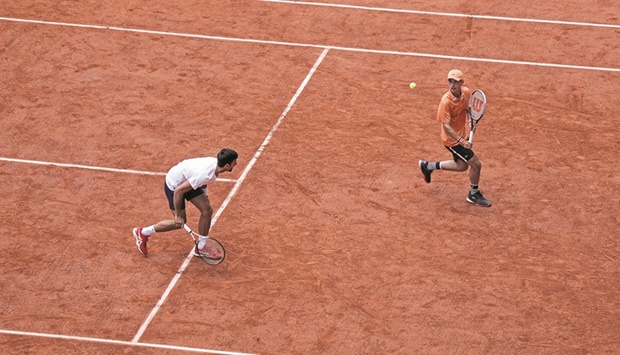 Serbiau2019s Novak Djokovic (left) plays with a ball boy during a training session at the Court Philippe-Chatrier, ahead of the French Open in Paris yesterday. (AFP)