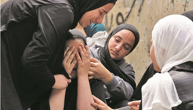 The sisters of 17-year-old Palestinian Amjad al-Fayed mourn his death, during his funeral in the refugee camp of Jenin, yesterday.