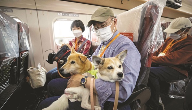 Passengers board a shinkansen bullet train with their dogs during a one-hour ride from Tokyo to the resort town of Karuizawa.