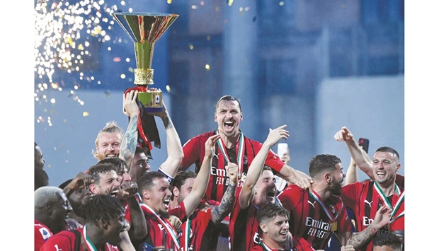 AC Milan players celebrate with the winneru2019s trophy after their Serie A match against Sassuolo in Sassuolo, Italy, yesterday. (AFP)