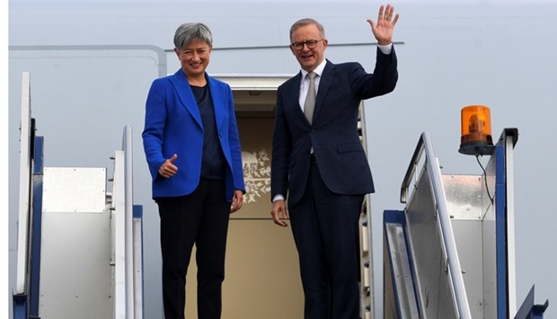 Australian Prime Minister Anthony Albanese, alongside Australian Foreign Minister Penny Wong, waves as the two board the plane to Japan to attend the QUAD leaders meeting in Tokyo, in Canberra, Australia. AAP Image/Lukas Coch via REUTERS