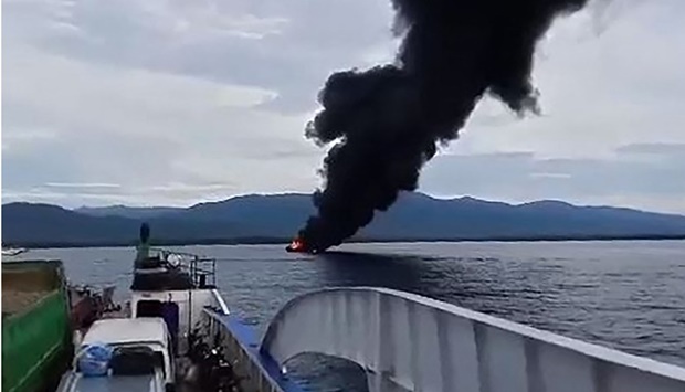 Black smoke rising from a burning ferry as seen from another ferry off Real town, Quezon province. Kycel Pineda/AFP