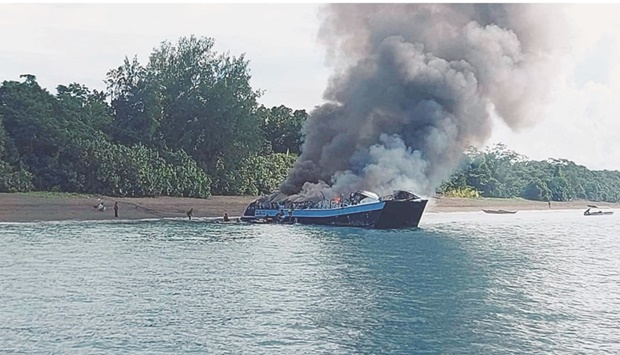 Smoke rises from the burning vessel near Real, Quezon province, Philippines, yesterday.