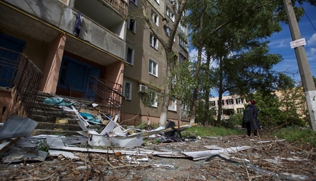 A local woman looks at an apartment building damaged by a Russian military strike, as Russia's attack on Ukraine continues, in the town of Vuhledar, in Donetsk region, Ukraine on May 22,. REUTERS