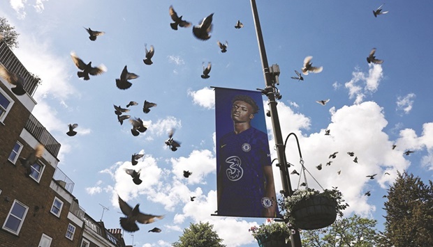 Pigeons fly past a banner outside Stamford Bridge, home ground of Chelsea, in London yesterday. (AFP)