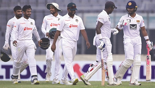 Sri Lankau2019s Dinesh Chandimal (right) and Angelo Mathews (second right) along with Bangladeshu2019s players walk back to the pavilion at the end of the third dayu2019s play of the second Test in Dhaka yesterday. (AFP)