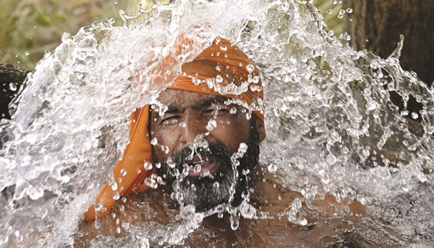 A farmer cools himself under a tubewell on a hot summer day on the outskirts of Amritsar last week. (AFP)