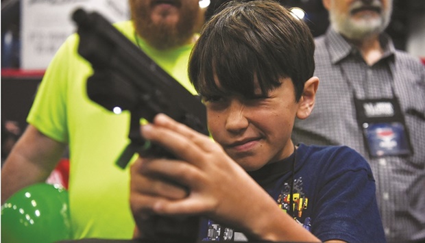 A child engages in virtual target practice as attendees try out the guns on display at the National Rifle Association (NRA) annual convention in Houston. (Reuters)