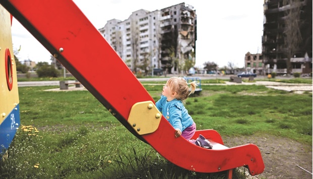 Two-year-old Nina Stefuryak plays at the playground in front of a building, destroyed by shelling, in Borodianka, Ukraine.