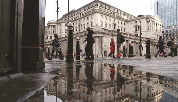 Pedestrians pass the Bank of England in the City of London. The BoE is expected to raise interest rates to their highest level in 13 years and clarify how it plans sell off some of its u00a3847bn in government bond holdings.