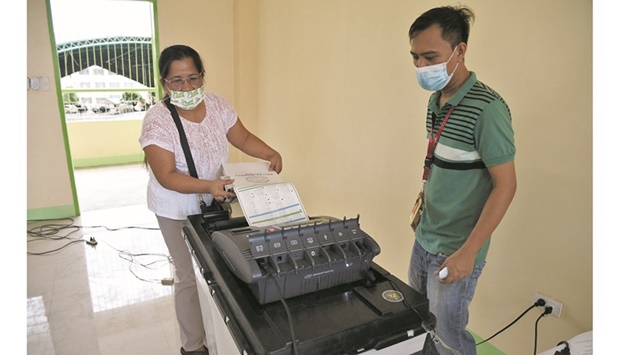 A poll worker simulates casting a vote at a polling station during preparations ahead of the May 9 presidential election, in Manila City, Philippines yesterday.