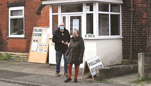 Voters leave a polling station set in the Heap Bridge social club, in Bury, northern England, during local elections, yesterday. Polls opened across the UK in local and regional elections that could prove historic in Northern Ireland and heap further pressure on embattled Prime Minister Boris Johnson.
