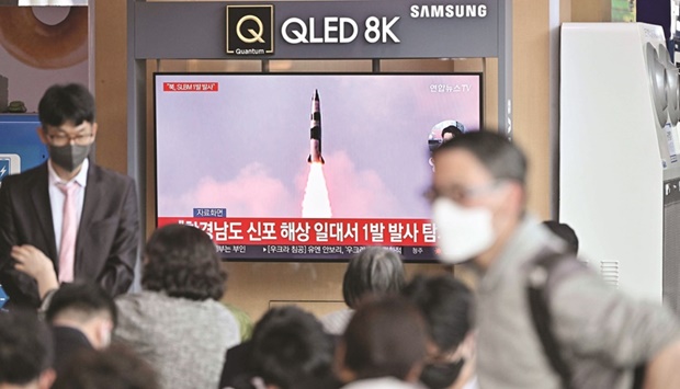 People watch a television screen showing a news broadcast with file footage of a North Korean missile test, at a railway station in Seoul yesterday.