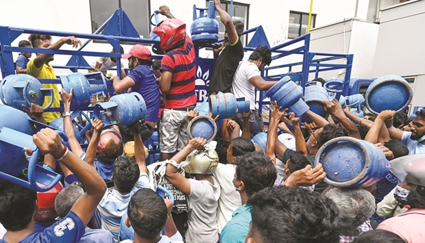Enraged crowd loot a truck transporting cooking gas cylinders in Colombo yesterday, after waiting in line overnight for supplies.