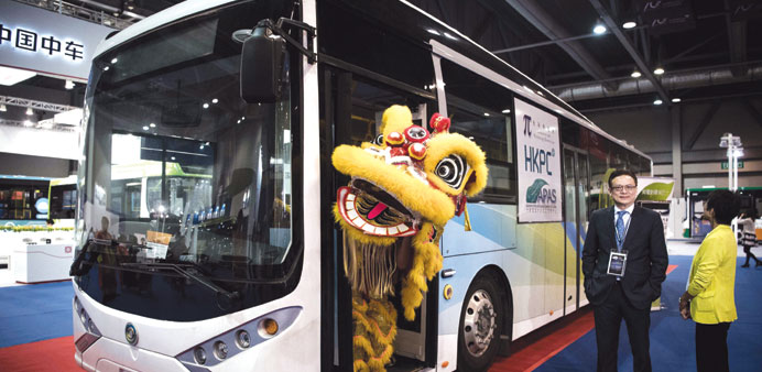 A performer wearing a lion dance costume stands in the door of an electric bus at the China International New Energy Vehicle show in Hong Kong.