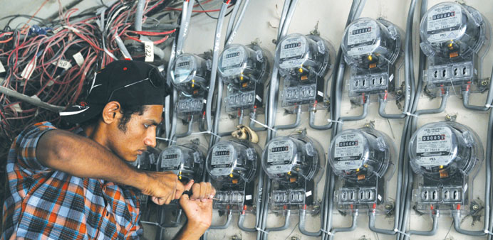 A technician from the Karachi Electric Supply Corporation (KESC), Pakistanu2019s largest cityu2019s power supply company, fixes new electricity meters at a re